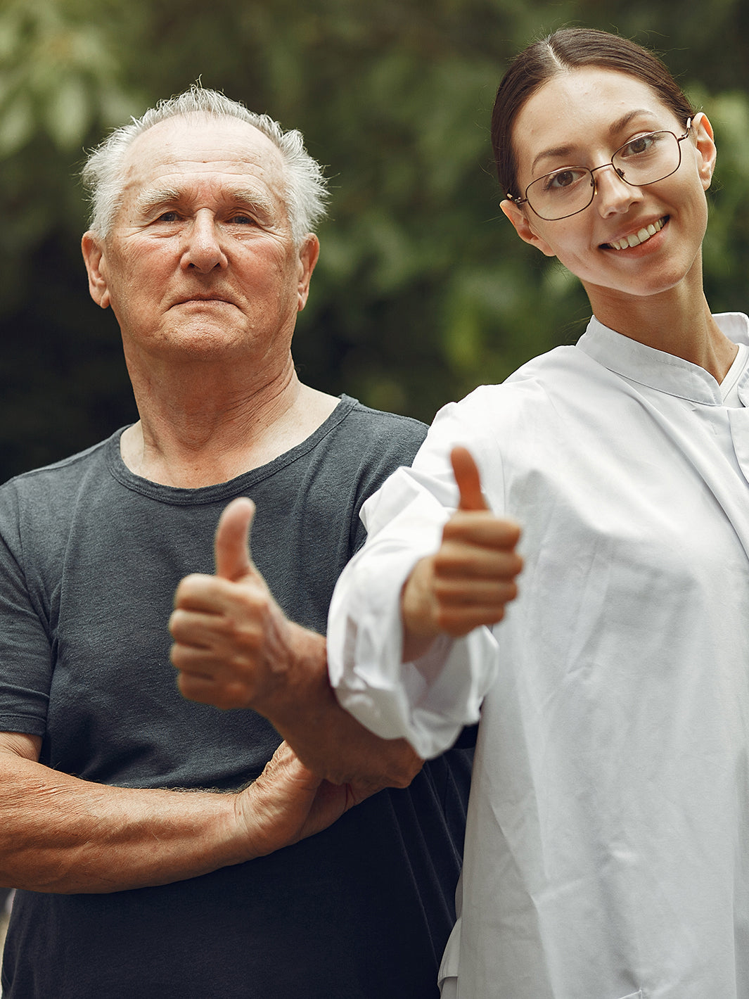 Older man with healthcare professional holding thumbs up indicating that it's all good