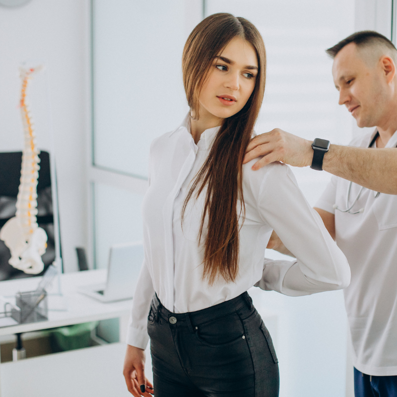 Professional woman getting her back assessed by chiropractor