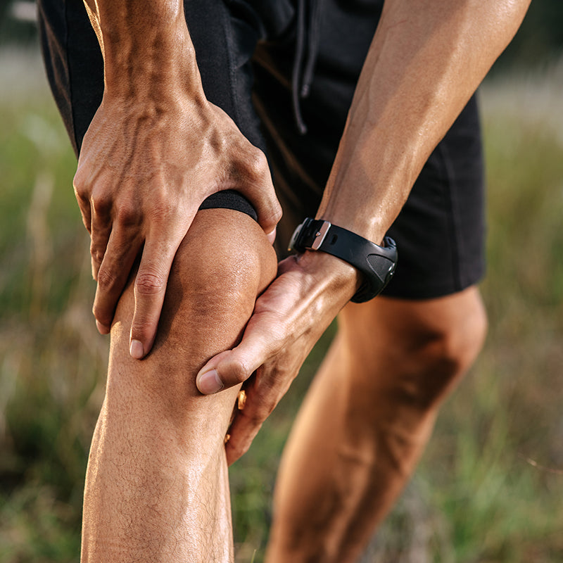 Man putting his hand on his knee like it is hurting