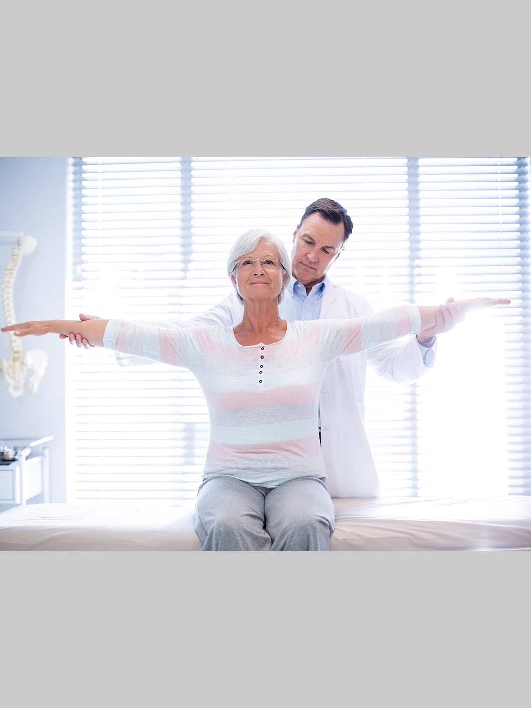 physical therapist examining senior woman's mobility 