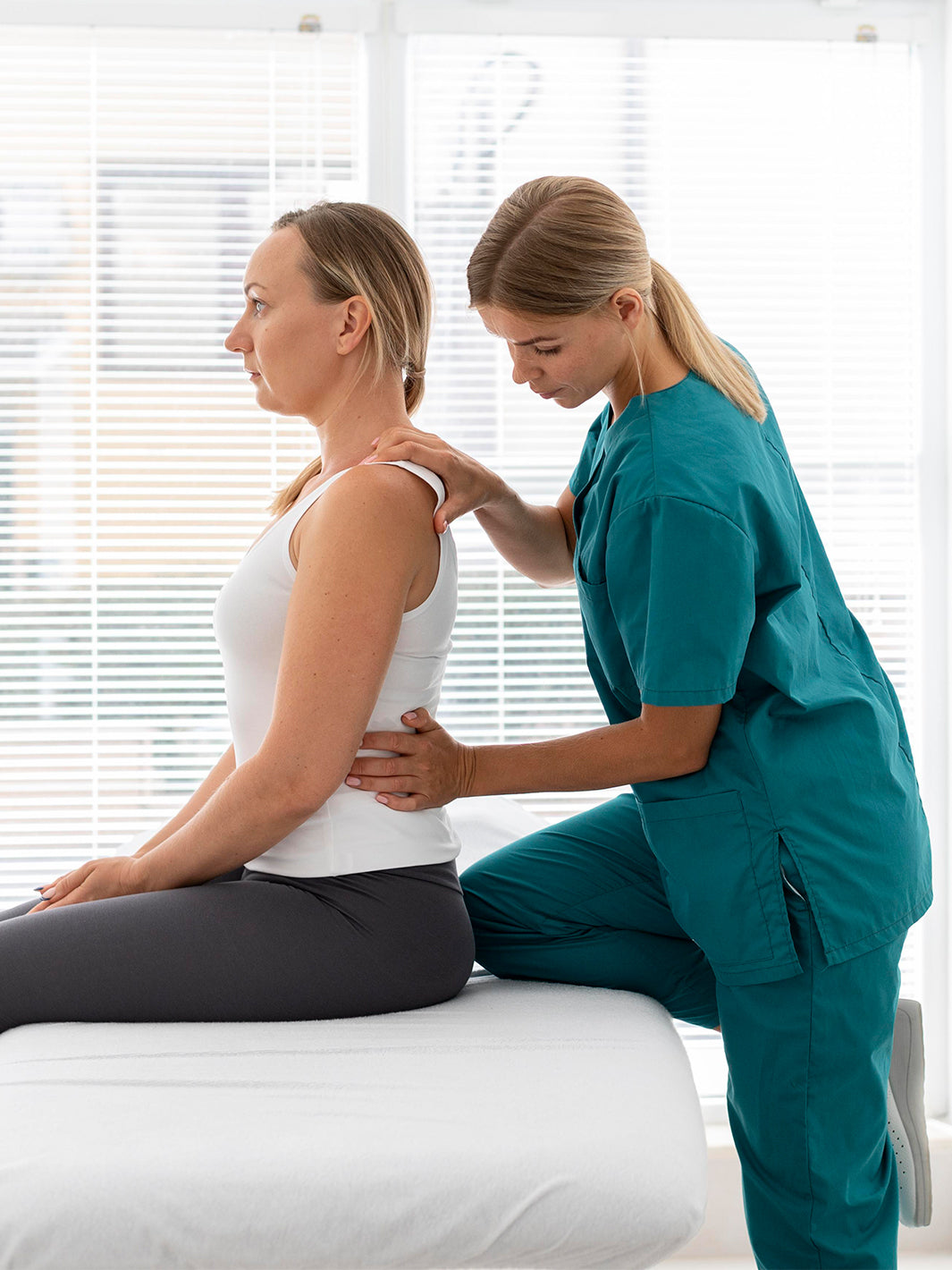 Woman getting her back adjusted by a healthcare professional